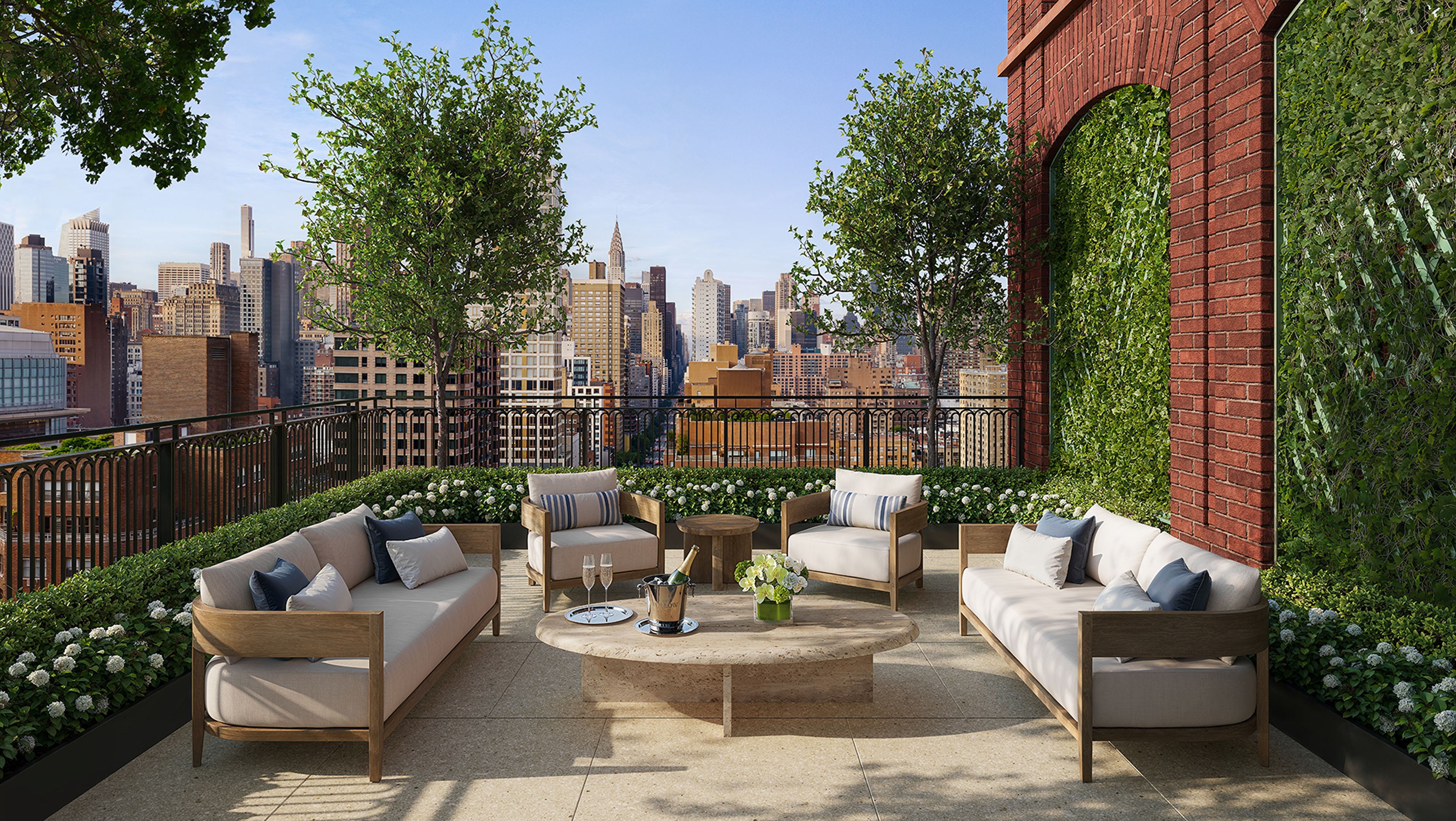 Furnished penthouse terrace with couches, greenery, and NYC skyline views at The Willow luxury residences in Gramercy.